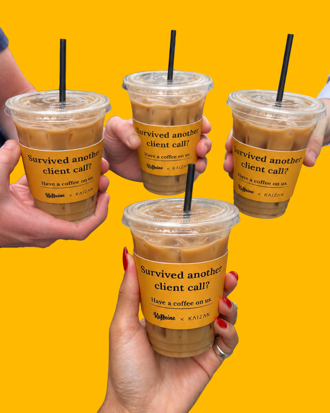 Four hands holding iced coffees with sleeves reading: Survived another client call? Have a coffee on us. Kaffeine x Kaizan.